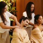 Men and women enjoying relaxing massages at a spa, surrounded by greenery, promoting wellness and relaxation.