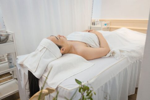 Woman enjoying a calming spa treatment indoors, wrapped in towels for ultimate relaxation.