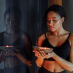 Peaceful woman holding a lit candle, reflecting calm and tranquility indoors.