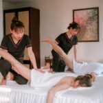Women receiving therapeutic massages in a serene spa setting, promoting relaxation and wellness.