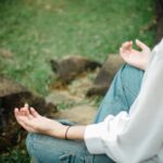A person meditates outdoors, embracing tranquility and mindfulness.
