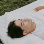 A peaceful moment of an adult resting outdoors on a pillow, embodying tranquility and comfort.