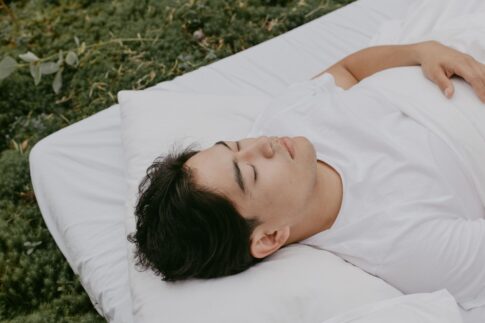 A peaceful moment of an adult resting outdoors on a pillow, embodying tranquility and comfort.