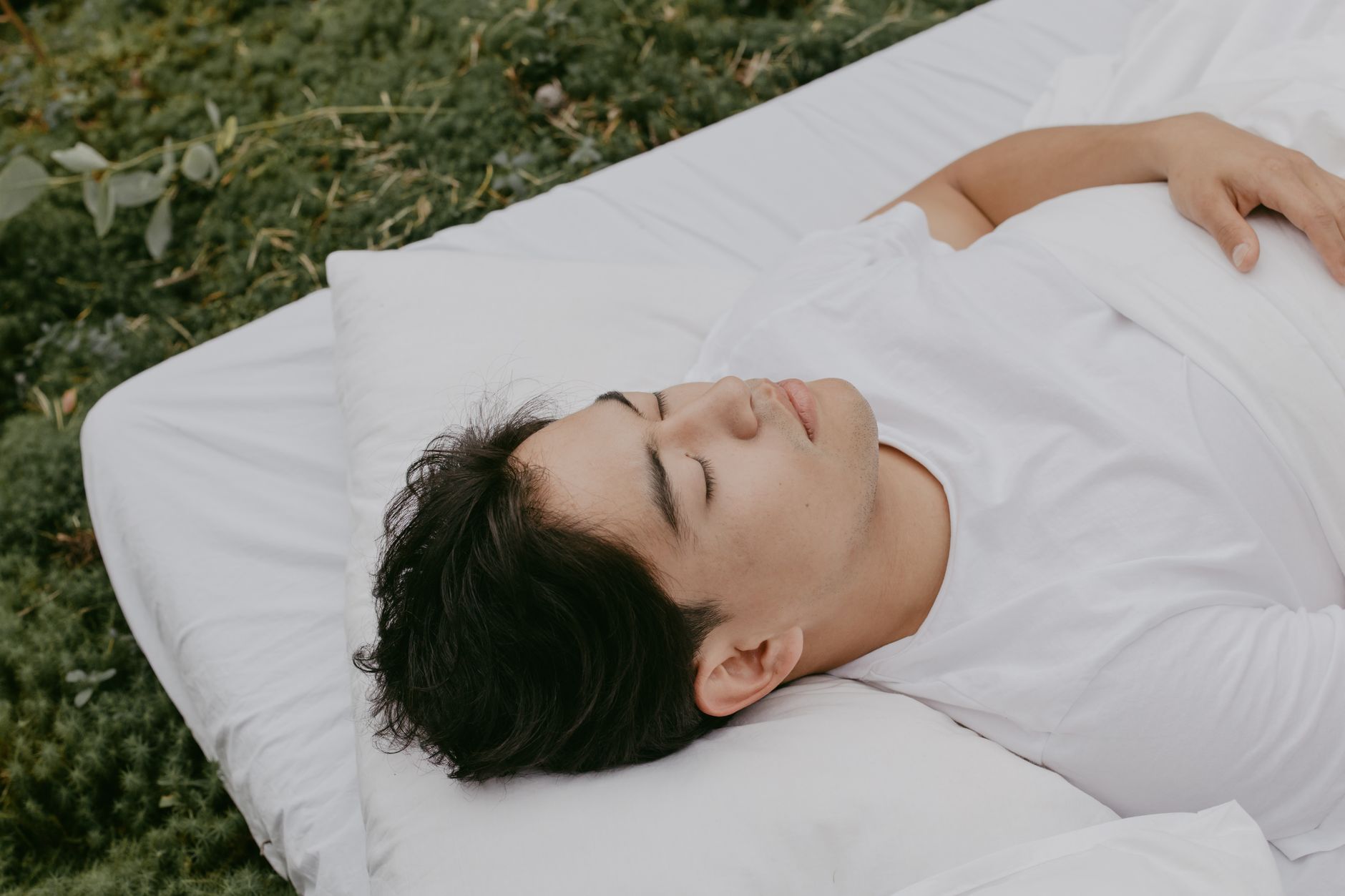 A peaceful moment of an adult resting outdoors on a pillow, embodying tranquility and comfort.